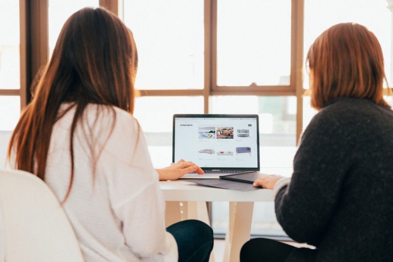 Two women in front of a laptop image